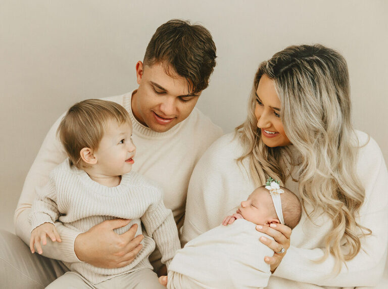 parents and sibling with newborn baby