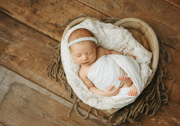 newborn baby in a heart bucket